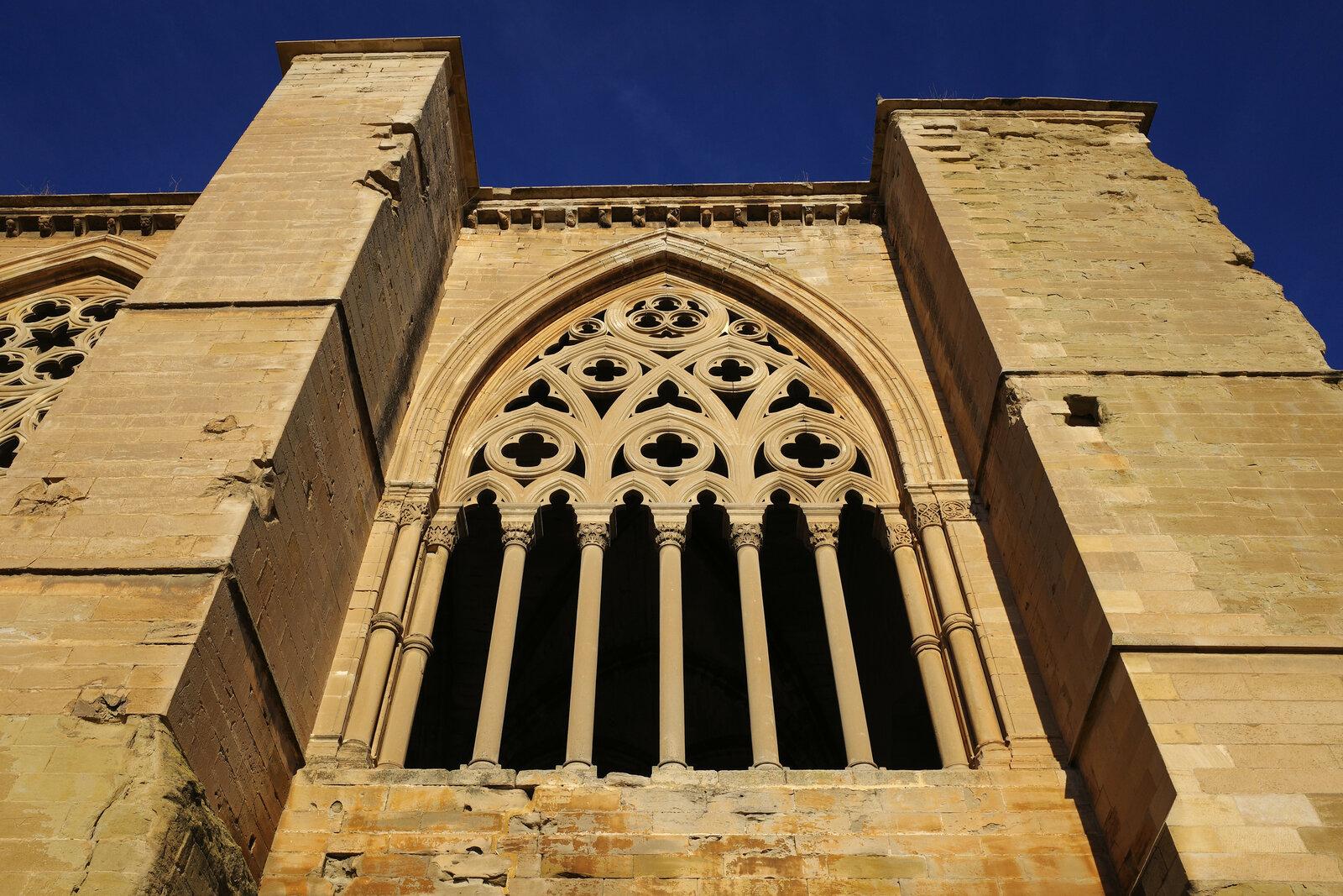 Carved Gothic window between stone buttresses at Lleida’s Seu Vella